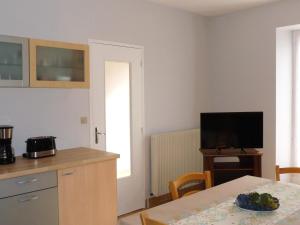 a kitchen with a table and a television and a dining room at Maison avec jardin clos et terrasse couverte en Touraine, proche des châteaux et nature préservée. - FR-1-381-574 in Manthelan