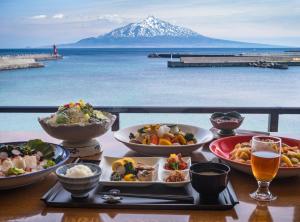 a table with plates of food and a mountain at REBUN Hotel SARYO in Kafuka