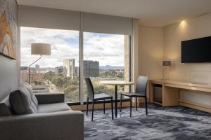 a living room with a table and chairs and a large window at Fairfield by Marriott Bogota Embajada in Bogotá