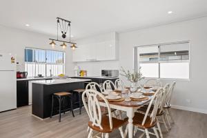 a kitchen and dining room with a table and chairs at C-Views - Aldinga Beach - C21 SouthCoast Holidays in Aldinga Beach