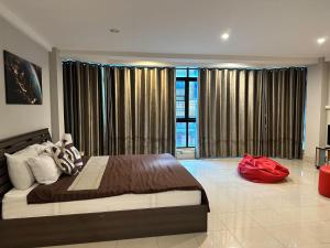 a bedroom with a large bed with a red bag on it at Take time house in Chiang Mai