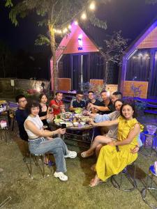 a group of people sitting around a table at a party at Yellow Homestay - Venuestay in Phú Thọ