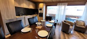 a dining room with a table and chairs and a kitchen at Résidence Cry De Lys - Appartement entièrement rénové, au pied des pistes MAE-8441 in Les Gets