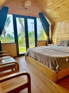 a bedroom with a bed in a room with windows at Yellow Homestay - Venuestay in Phú Thọ