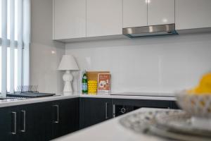 a kitchen with white cabinets and a counter top at C-Views - Aldinga Beach - C21 SouthCoast Holidays in Aldinga Beach