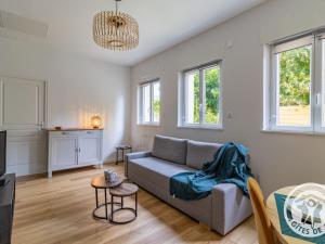 a living room with a couch and a table at Maison rénovée avec jardin proche d'Angers - FR-1-622-92 in Rochefort-sur-Loire