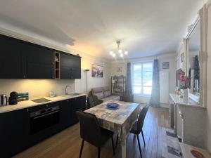 a kitchen and living room with a table and chairs at Charmant studio au centre du Mont-Dore, bien équipé, max 2 pers - FR-1-608-273 in Mont-Dore