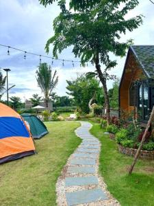 a garden with a tent and a walkway at Yellow Homestay - Venuestay in Phú Thọ