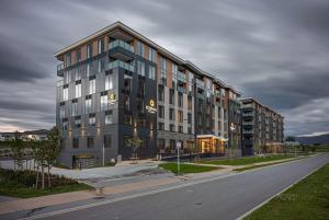 Un gran edificio en una calle de la ciudad con una carretera. en La Quinta by Wyndham Remarkables Park Queenstown, en Queenstown