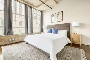 una camera da letto con un grande letto bianco e finestre di Reside Houston Downtown, a Wyndham Residence a Houston