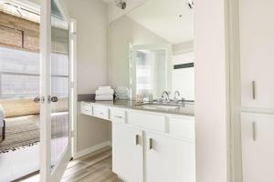 bagno bianco con lavandino e specchio di Reside Houston Downtown, a Wyndham Residence a Houston Altre 37 foto