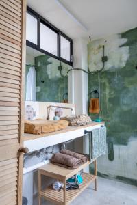 ein Badezimmer mit Waschbecken und einem Regal mit Handtüchern in der Unterkunft Gran casa para amigos a 4 cuadras del Zocalo in Oaxaca de Juárez