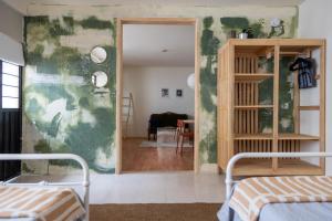 ein Wohnzimmer mit zwei Betten und einer Tür zu einem Zimmer in der Unterkunft Gran casa para amigos a 4 cuadras del Zocalo in Oaxaca de Juárez