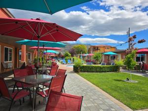 a table and chairs with umbrellas on a patio at Sahara Courtyard Inn & Suites Osoyoos in Osoyoos