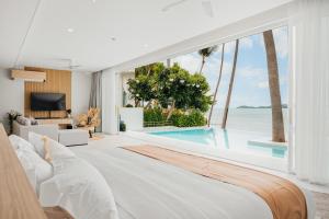 a bedroom with a large bed and a swimming pool at Beachfront Secret Tides Villa Sol in Koh Samui 
