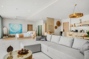 a living room with a couch and a kitchen at Beachfront Secret Tides Villa Sol in Koh Samui 