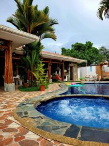 a swimming pool in front of a house at La CASA DE LA ABUELA in Sucúa