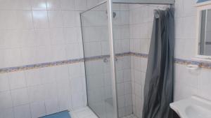 a shower with a glass door in a bathroom at De'moore Guest House in Johannesburg +2 photos