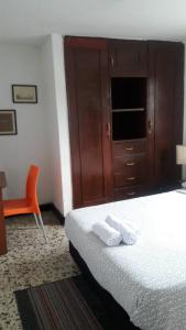 a bedroom with a bed and a dresser and a chair at VIVIENDA TURISTICA Grand Royal Inn in Barranquilla +4 photos