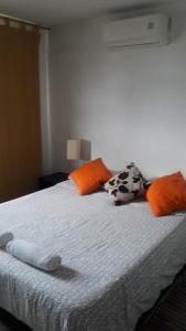 a bed with orange and orange pillows on it at VIVIENDA TURISTICA Grand Royal Inn in Barranquilla