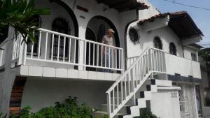 a man standing on the balcony of a house at VIVIENDA TURISTICA Grand Royal Inn in Barranquilla