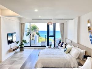 a bedroom with a bed and a view of the ocean at 墾丁山海晴民宿 in Eluan +69 photos
