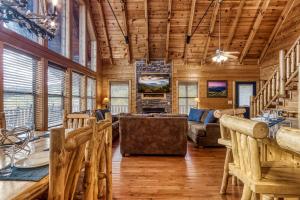 a log cabin living room with a couch and chairs at Hang Tenn in Sevierville