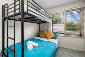a bedroom with a bunk bed with a blue bed at Otway Vista Five in Apollo Bay