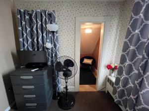 ハートフォードにあるPrivate Room Minutes from Downtown Aのドレッサーと扇風機付きのドアのある部屋 +1枚の写真
