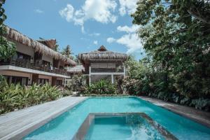 a swimming pool in front of a house at Caracoa Resort in General Luna