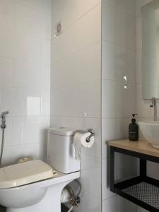 a white bathroom with a toilet and a sink at Damansara Empire Cozy Industrial Style 4 pax in Petaling Jaya