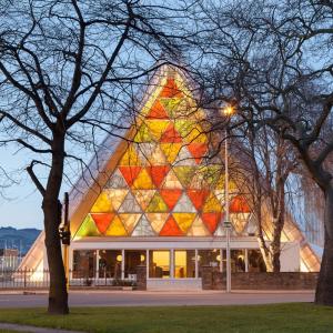 a building with a pyramid shaped facade with trees at The City's Best Kept Secret 2 bed 2 bath in Christchurch