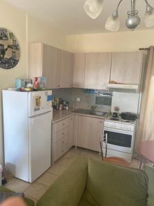 a kitchen with a white refrigerator and a stove at RIAS view in Nea Potidaea