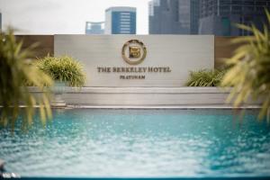 a hotel sign with a swimming pool in front of it at The Berkeley Hotel Pratunam in Bangkok