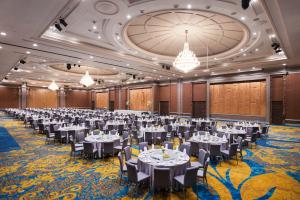 a banquet hall with tables and chairs and chandeliers at The Berkeley Hotel Pratunam in Bangkok