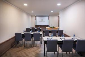 a conference room with tables and chairs and a projection screen at The Berkeley Hotel Pratunam in Bangkok