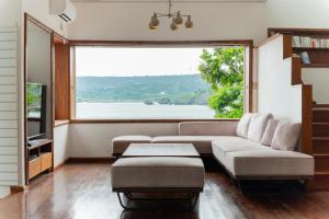 宇流麻ASAHi的带沙发和大窗户的客厅