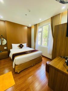 a bedroom with a large bed and a window at Queen Villa 3 Hotel DL - by BAY LUXURY in Da Lat