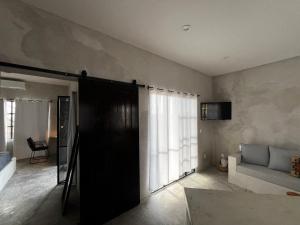a living room with a black door and a couch at Ocean View, Gorgeous Rooftop, AC, Wifi & Peaceful in Todos Santos
