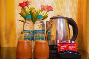 three bottles of water sitting next to a tea kettle at Ride At Hill-Nihal Hotel & Cottage in Manāli