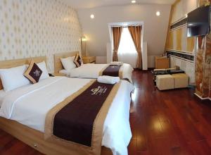 a hotel room with two beds and a television at Queen Villa Hotel 2 DL - by BAY LUXURY in Da Thien