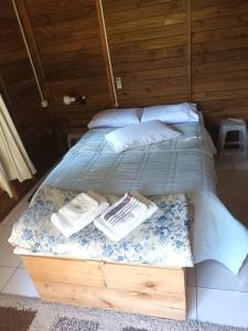 a bedroom with a bed with two pillows and a box at Cabana aconchegante na natureza in Rancho Queimado