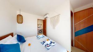 a bedroom with a white bed with blue pillows at Segara Seaside Resort in Nusa Lembongan