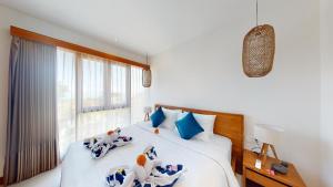 a bedroom with a bed with blue and white pillows at Segara Seaside Resort in Nusa Lembongan