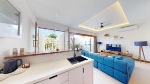 a living room with a blue couch and a blue sofa at Segara Seaside Resort in Nusa Lembongan