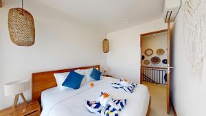 a bedroom with a bed with blue and white pillows at Segara Seaside Resort in Nusa Lembongan