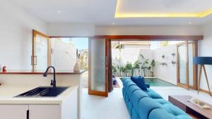 a kitchen and living room with a blue couch at Segara Seaside Resort in Nusa Lembongan