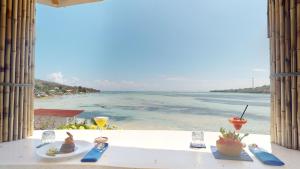 a table with a view of the ocean from a window at Segara Seaside Resort in Nusa Lembongan