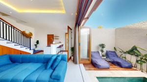 a living room with a blue couch and some plants at Segara Seaside Resort in Nusa Lembongan +37 photos