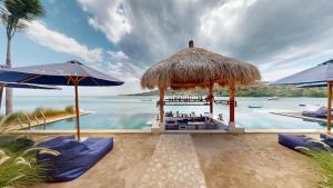 a bar on the beach next to the water at Segara Seaside Resort in Nusa Lembongan